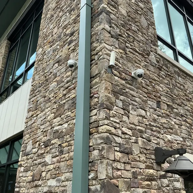 Security cameras mounted on a stone commercial building