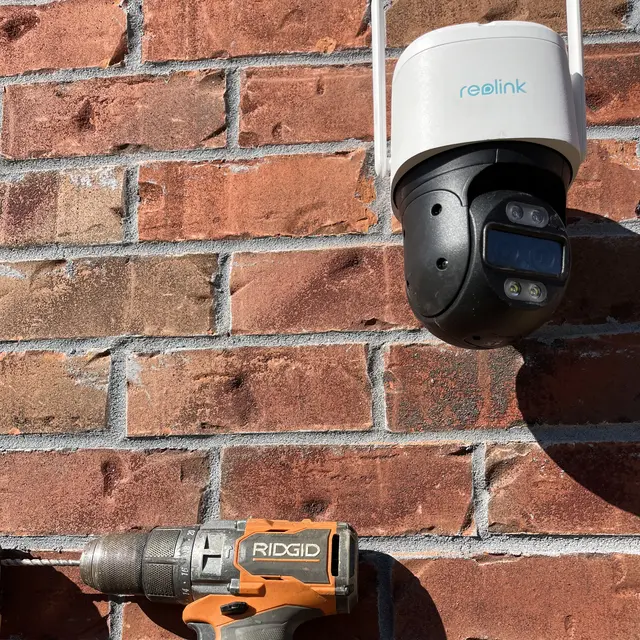Outdoor pan and tilt camera installed on a brick wall